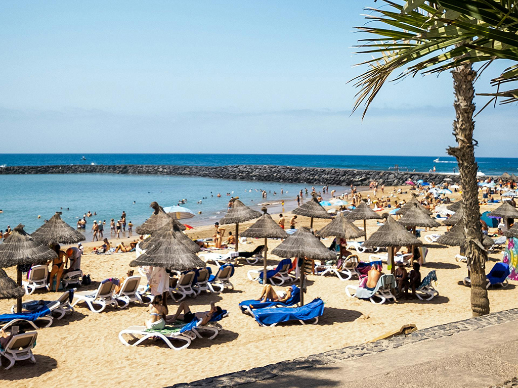 Women practicing yoga at sunset overlooking the ocean